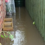 20.09 Back of No. 19 garage showing flow still coming from driveway of Four Winds towards Trail