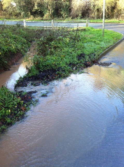 Trench cut through verge at bottom of Park Lane to prevent water running onto Nottingham Road.